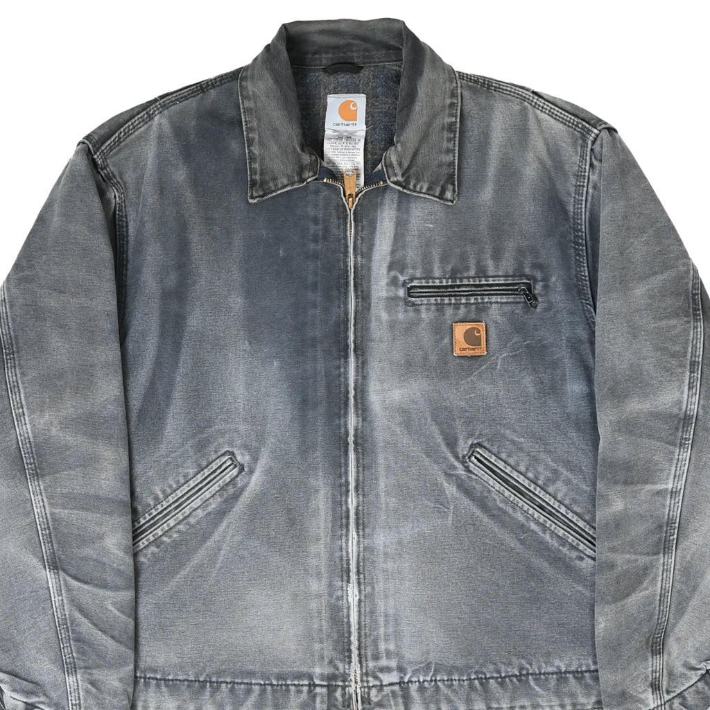 Front detail of faded gray Carhartt Detroit jacket with zip chest pocket and logo patch