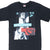 Front upper view of black Nike Andre Agassi T-shirt with turquoise, white, red and gray tennis graphic