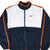 Front close-up of Nike windbreaker with navy, white and orange color blocking and embroidered Swoosh