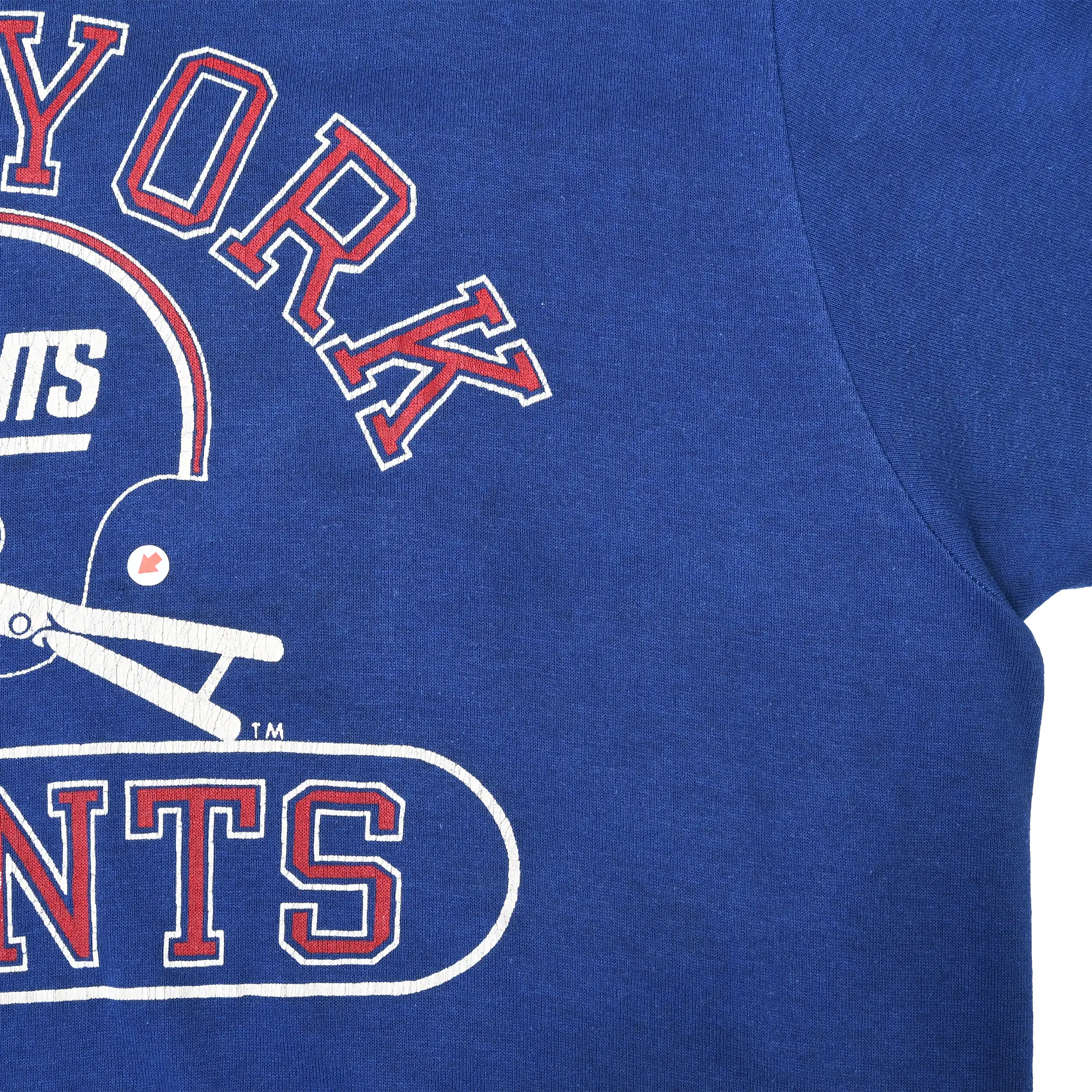 Close-up of New York Giants chest print, blue fabric, and right underarm seam