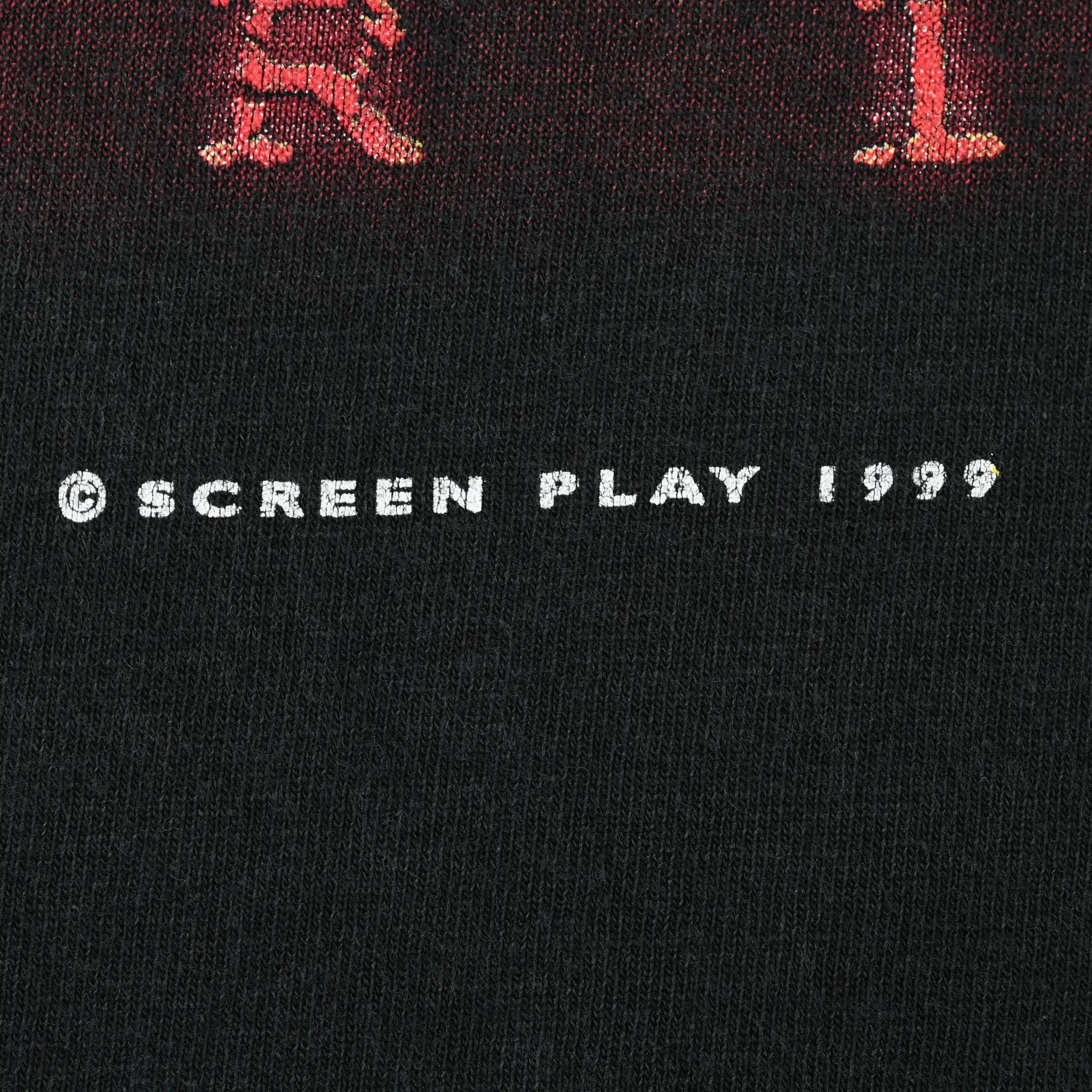 Close-up of Screen Play 1999 copyright text on black fabric