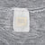 Close-up of faded neck tag and collar stitching on gray T-shirt