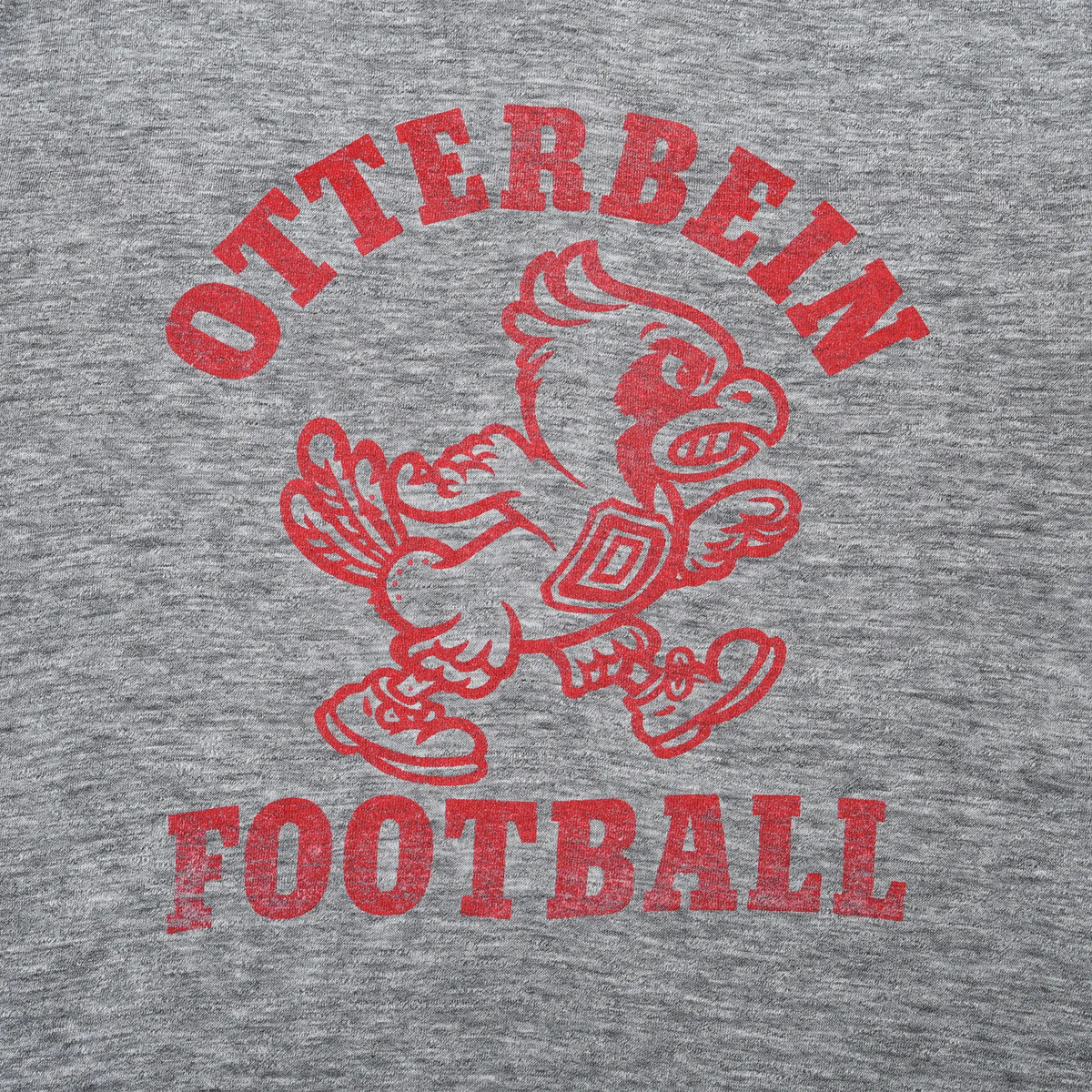 Close-up of red Otterbein Football cardinal graphic on gray T-shirt