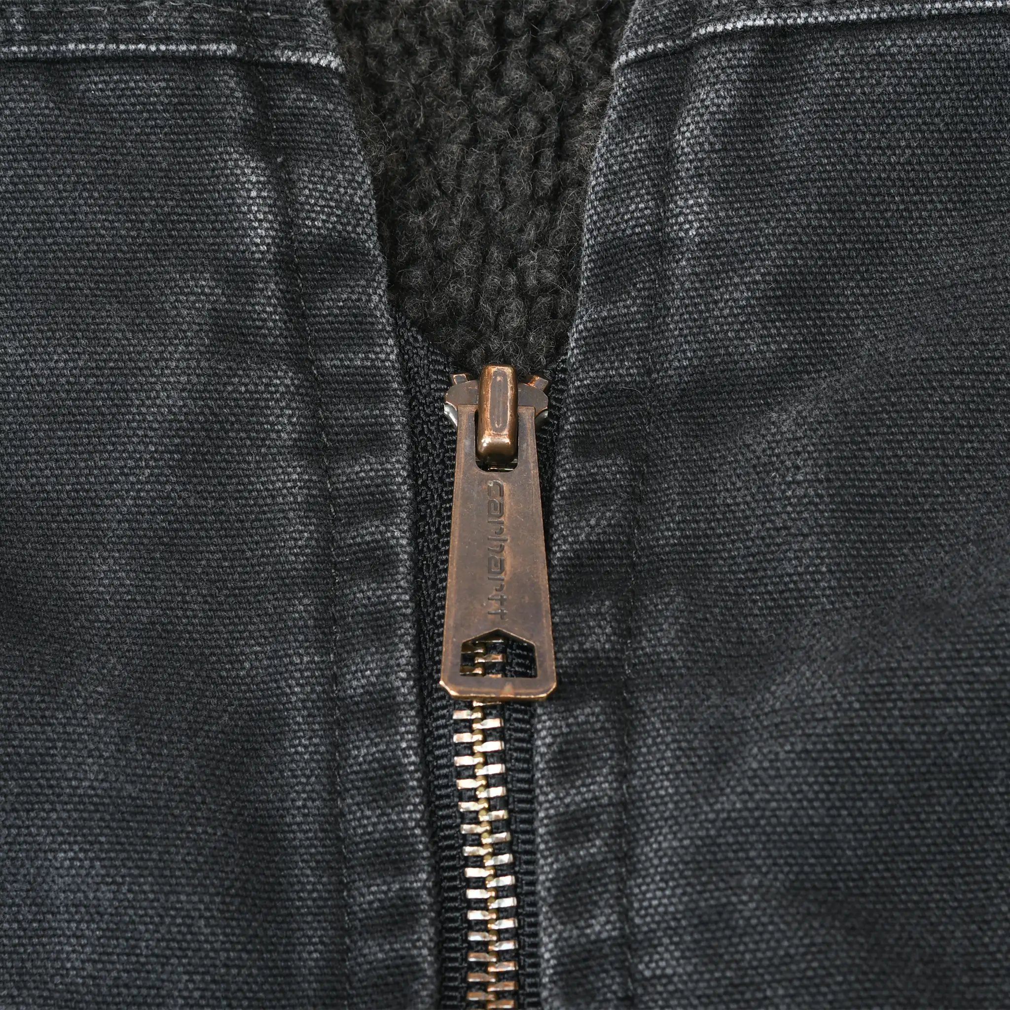 Close-up of Carhartt metal zipper pull and black sherpa lining