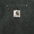 Close-up of chest pocket with stitched Carhartt logo patch and metal rivets