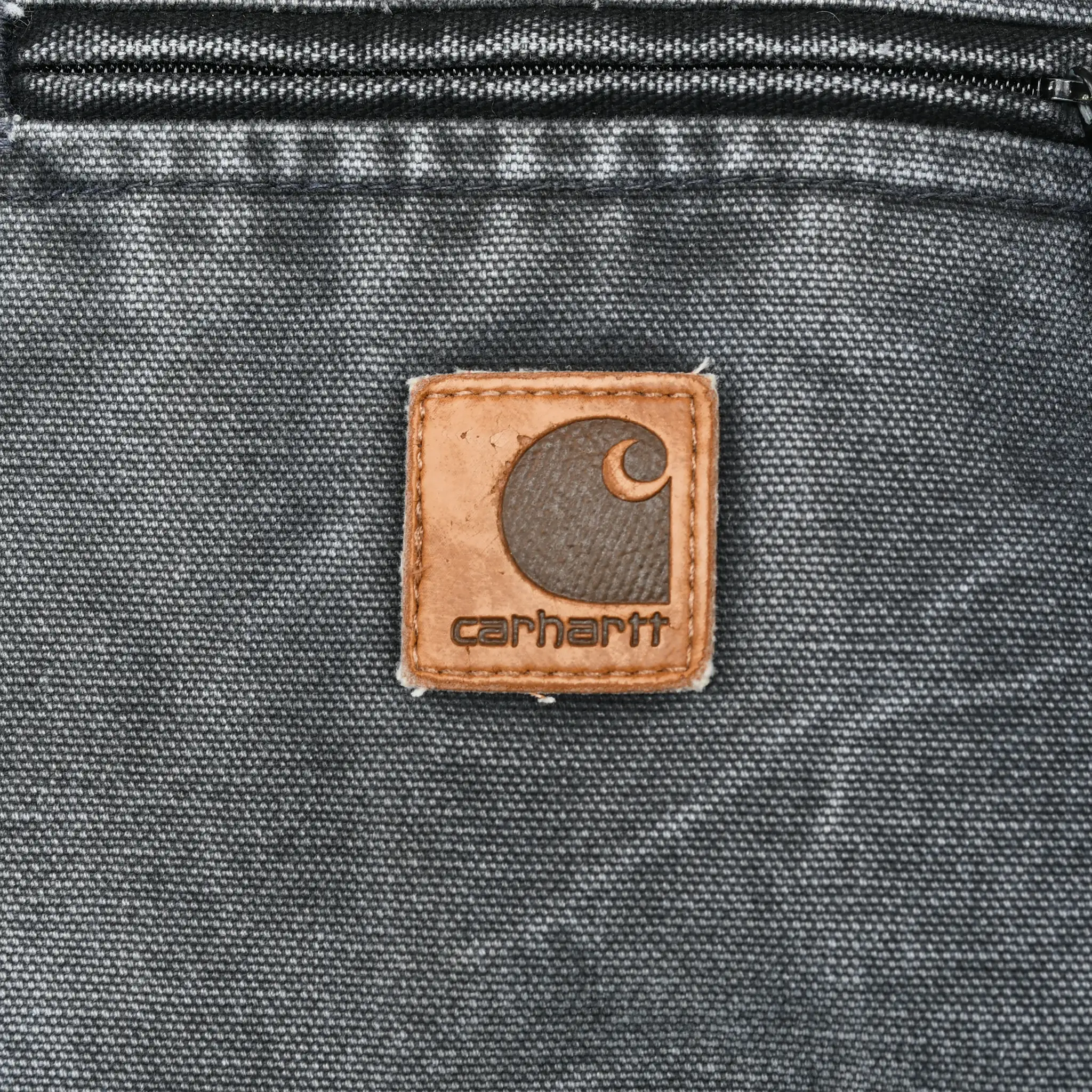 Close-up of Carhartt logo patch below the zip chest pocket