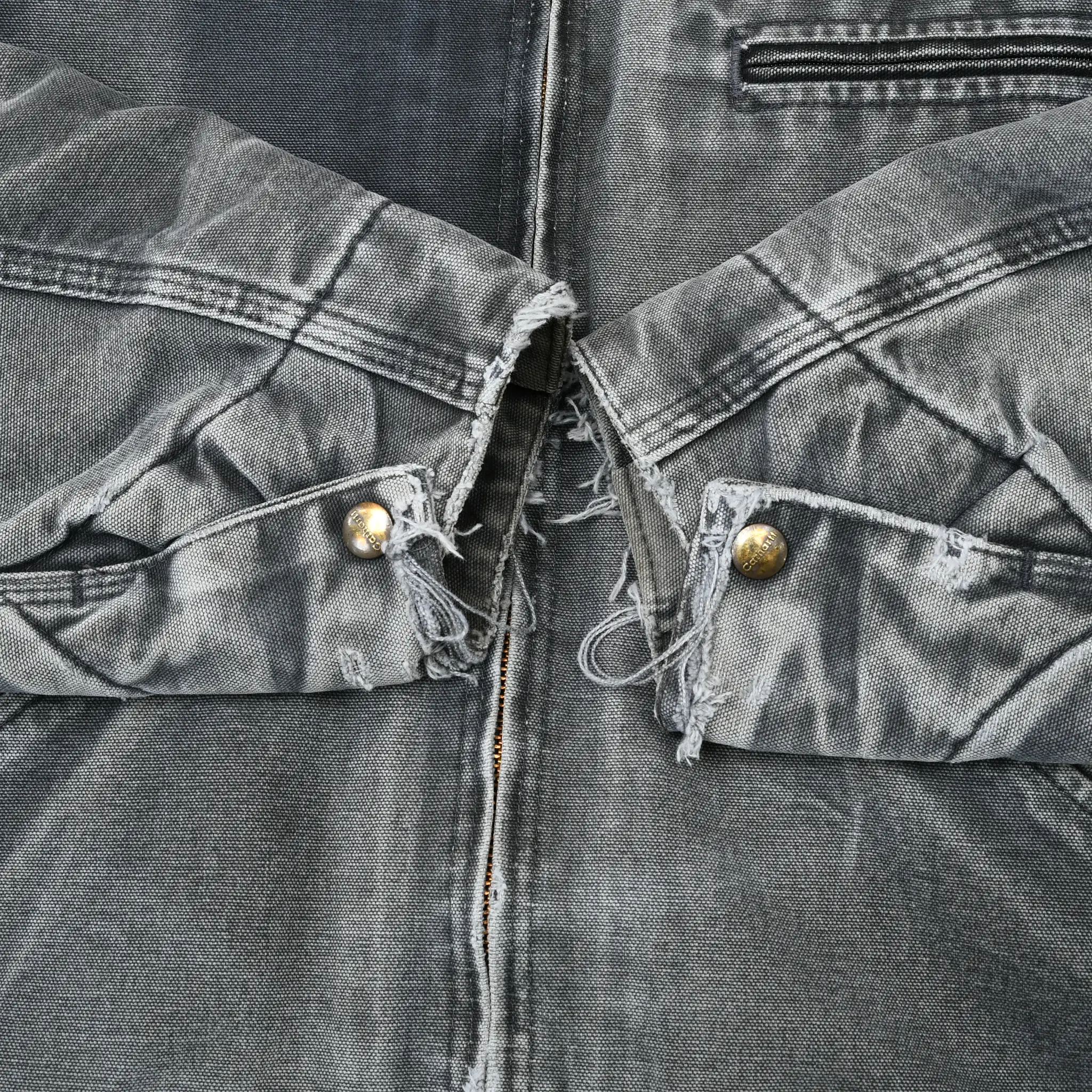 Close-up of frayed interior waist adjustment tabs with brass-tone snaps