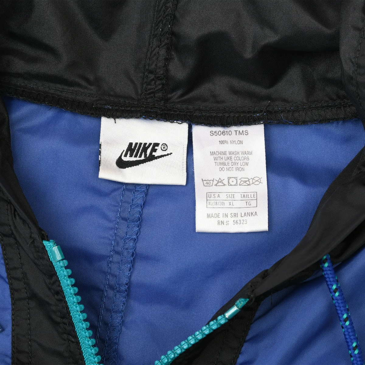 Close-up of Nike neck and care labels inside blue and black windbreaker
