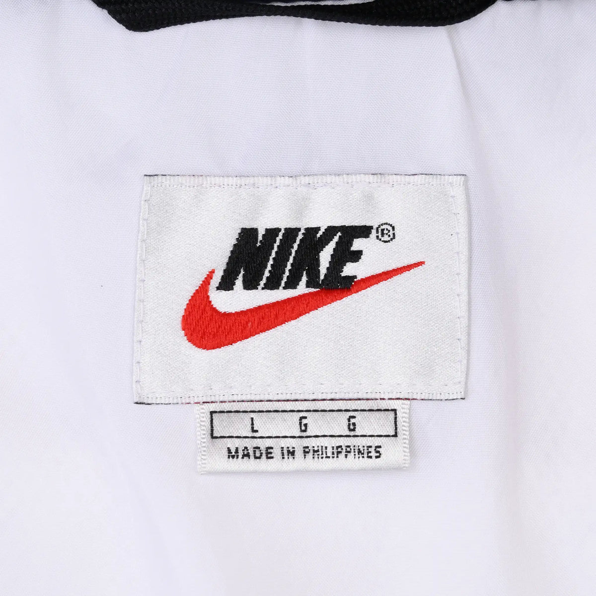 Nike neck label with black logo, red Swoosh and large size marking