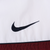 Close-up of navy Nike Swoosh embroidery on white chest panel