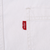 Close-up of red Levi's tab stitched beside chest pocket on white denim shirt