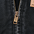 Close-up of brass Carhartt zipper on black jacket fabric