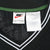 Close-up of Nike neck and care labels inside the black striped V-neck collar