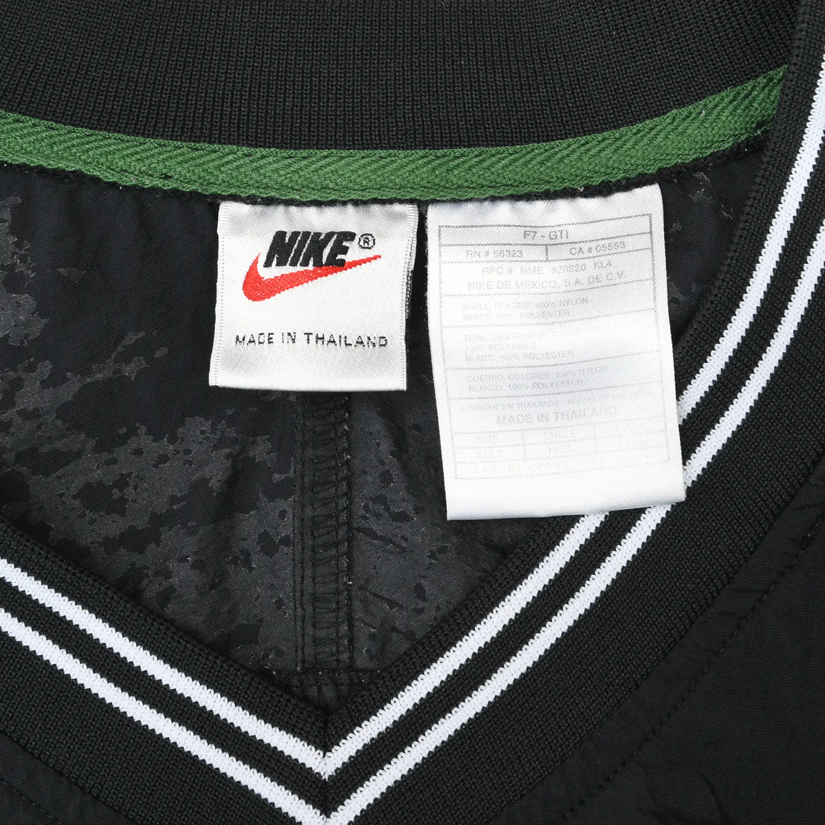 Close-up of Nike neck and care labels inside the black striped V-neck collar