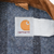 Carhartt logo neck label on gray blanket lining beneath brown corduroy collar