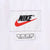Close-up of white Nike neck label with black logo and red Swoosh
