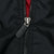 Close-up of black front zipper with Nike Swoosh pull and red lining