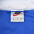 Nike neck label showing size medium inside blue pullover windbreaker