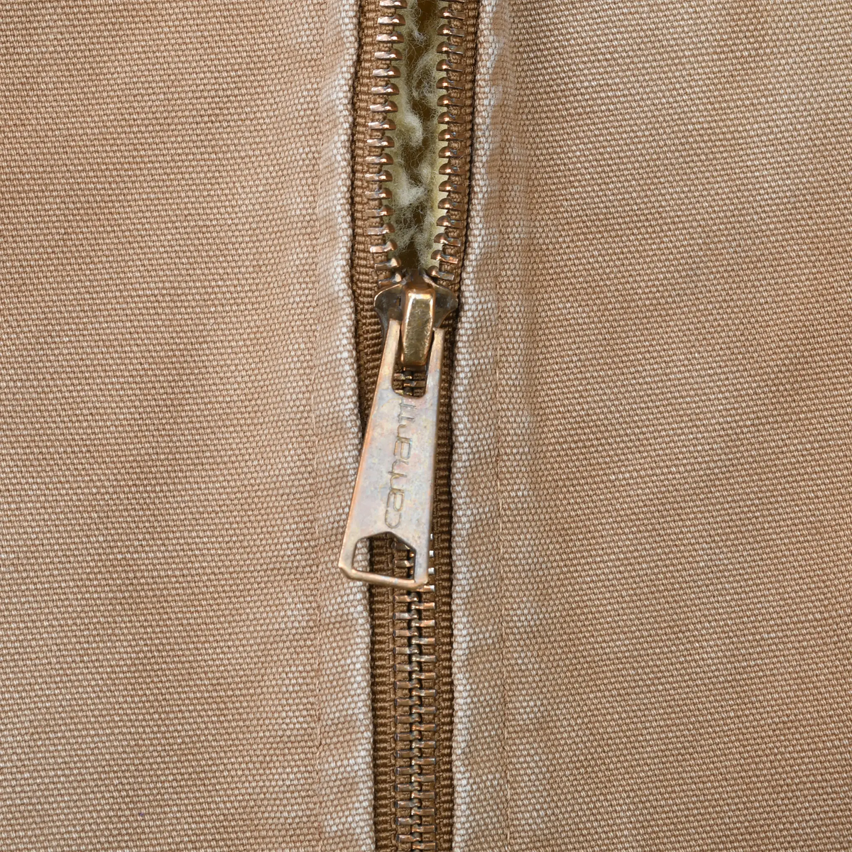 Close-up of Carhartt metal zipper and pull on brown vest