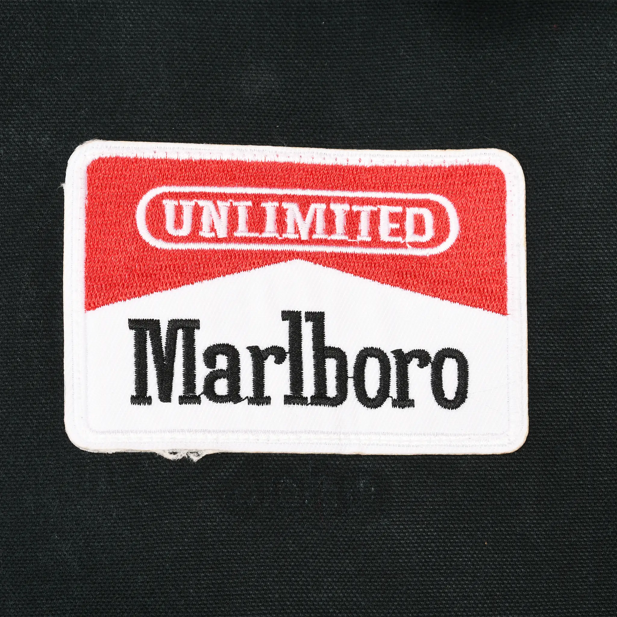 Close-up of red, white, and black Unlimited Marlboro embroidered chest patch