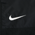 Close-up of white Nike Swoosh embroidery on black jacket front