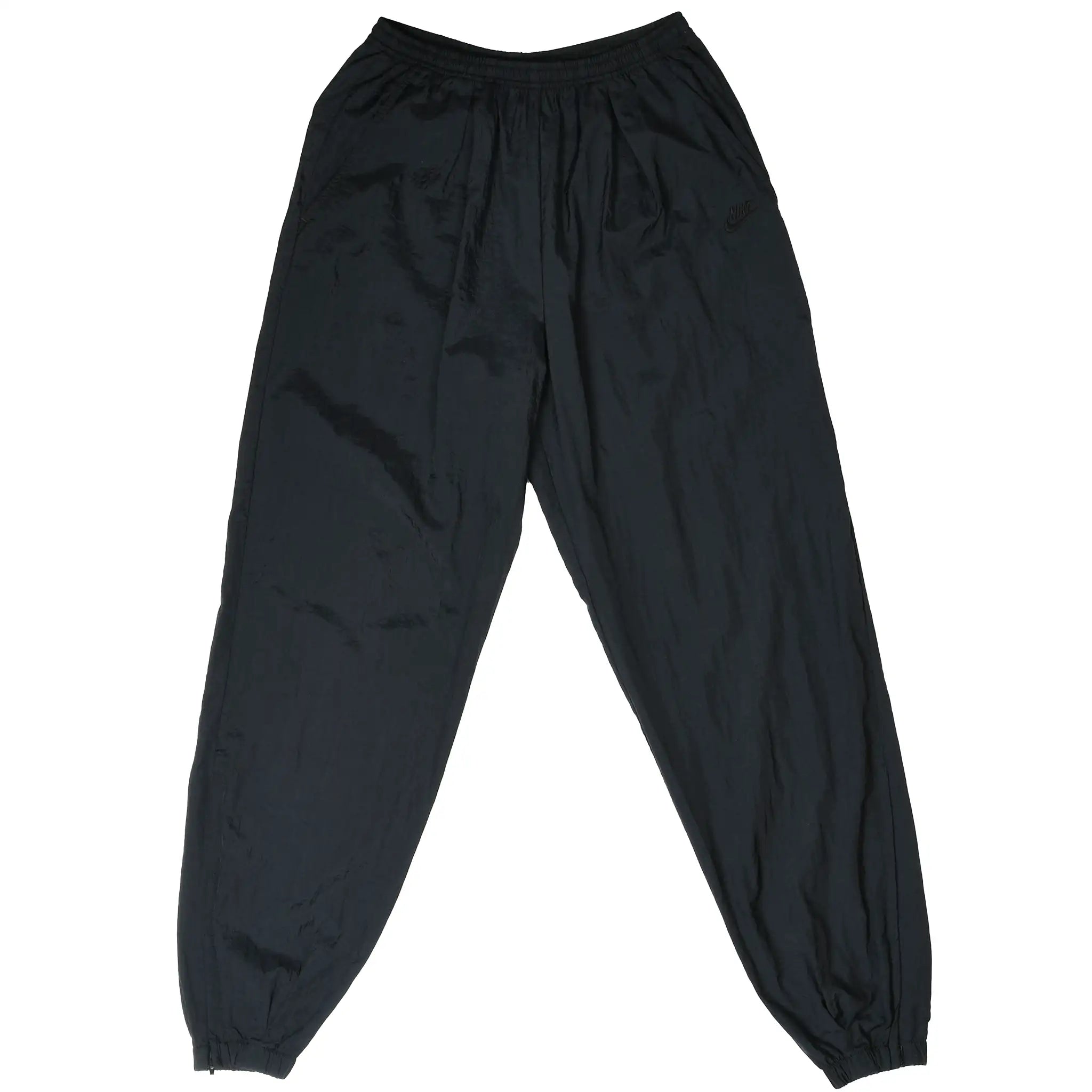 Front of black Nike nylon track pants with elastic waist and cuffs