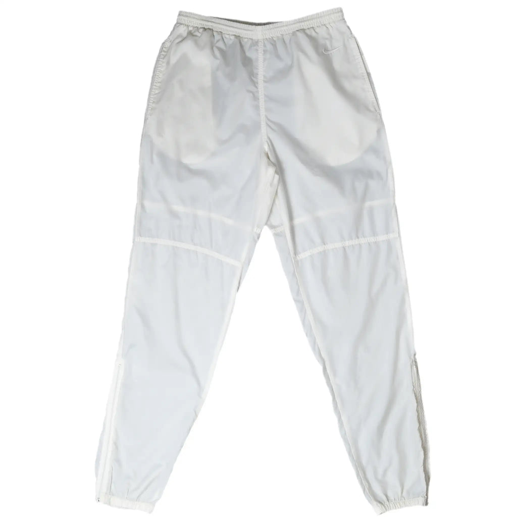 Front of white Nike track pants with elastic waist, curved knee seams, and elastic cuffs