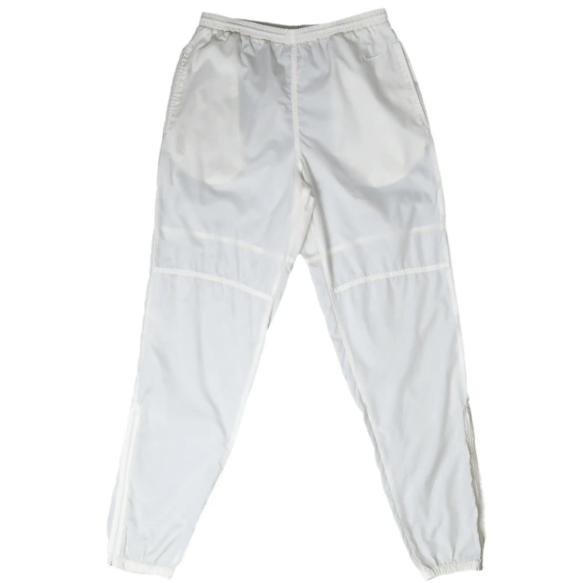Front of white Nike track pants with elastic waist, curved knee seams, and elastic cuffs