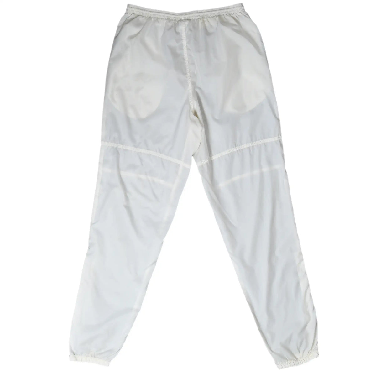 Back of white Nike track pants with elastic waist, curved knee seams, and elastic cuffs