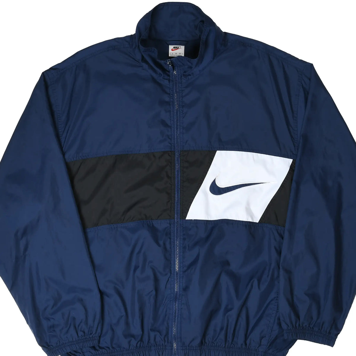Front of navy Nike windbreaker with black chest panel and white inset Swoosh