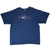 Full front view of blue Nike T-shirt with centered Swoosh, oval, stripes, and stars