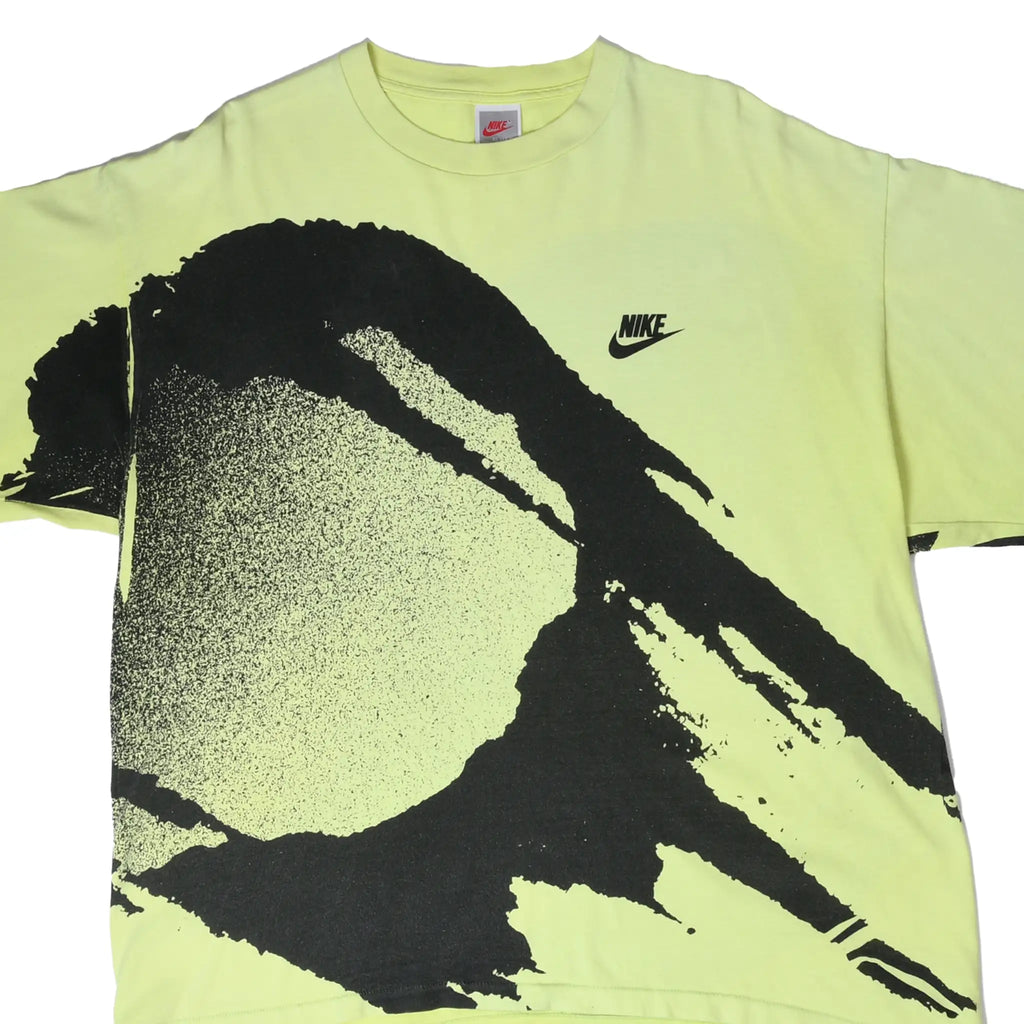 Front of neon yellow Nike tennis T-shirt with oversized black all-over racket and ball print