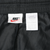 Interior Nike logo and care labels at the waistband of black track pants