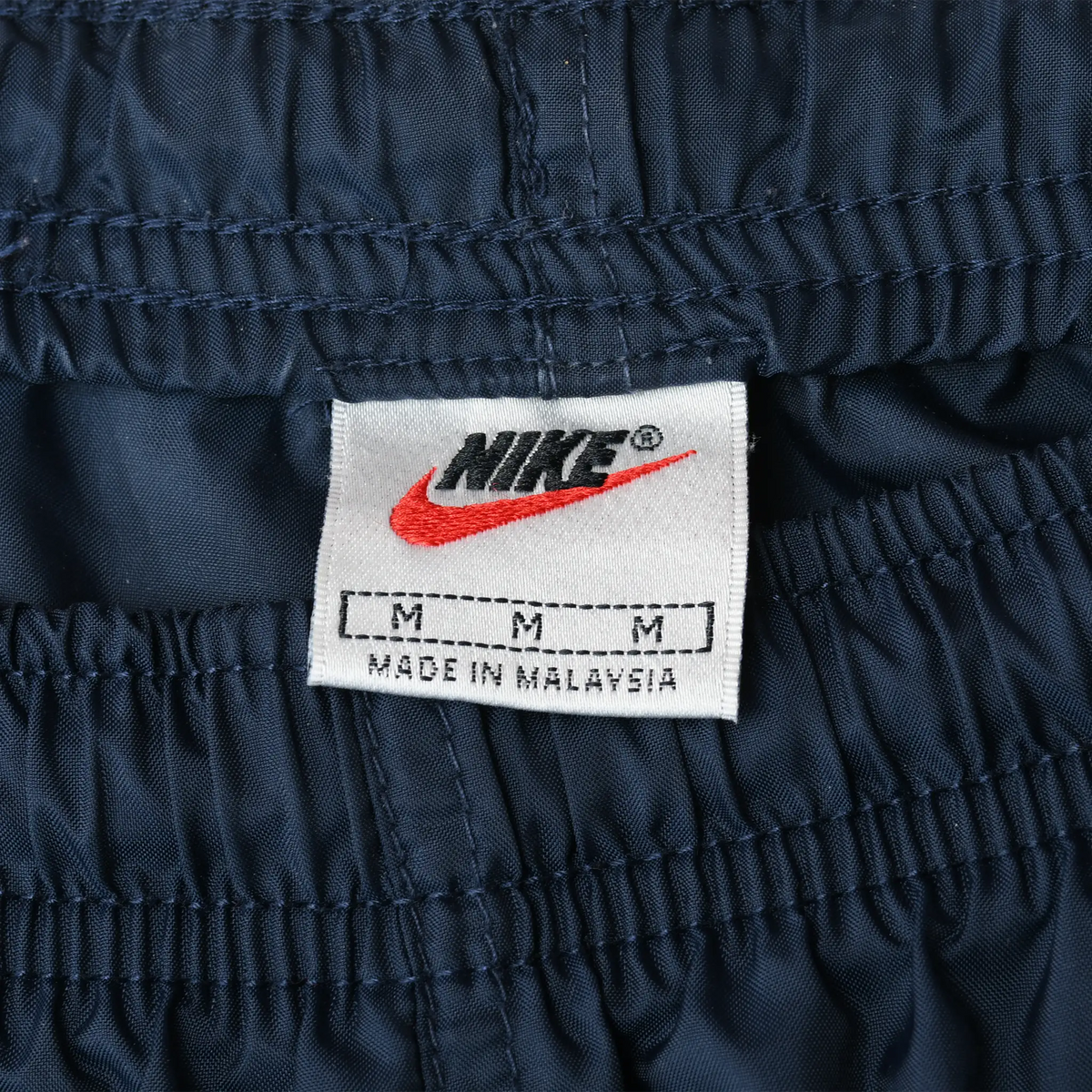 Nike waistband label with red Swoosh and size M marking