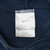 Close-up of white Nike Swoosh neck tag inside navy blue hoodie