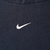 Close-up of white Nike Swoosh embroidery centered on navy blue hoodie chest
