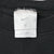 Close-up of white Nike neck label inside black sweatshirt