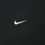 Close-up of small white Nike Swoosh embroidery on black fabric