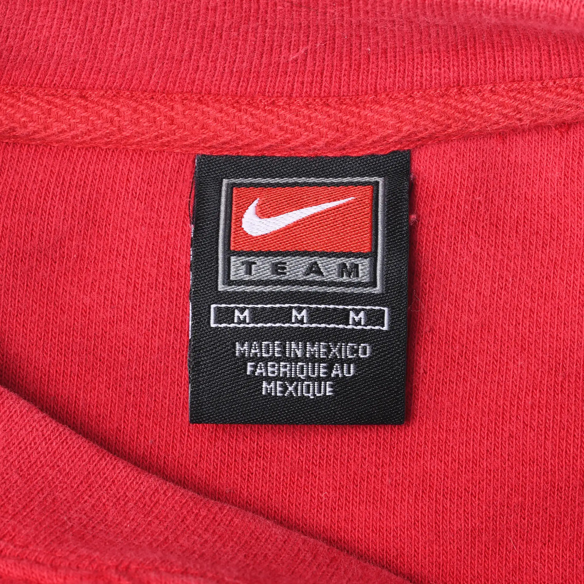 Close-up of black Nike Team medium neck label inside red sweatshirt