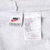 Close-up of Nike neck and care labels marked size large inside grey hoodie