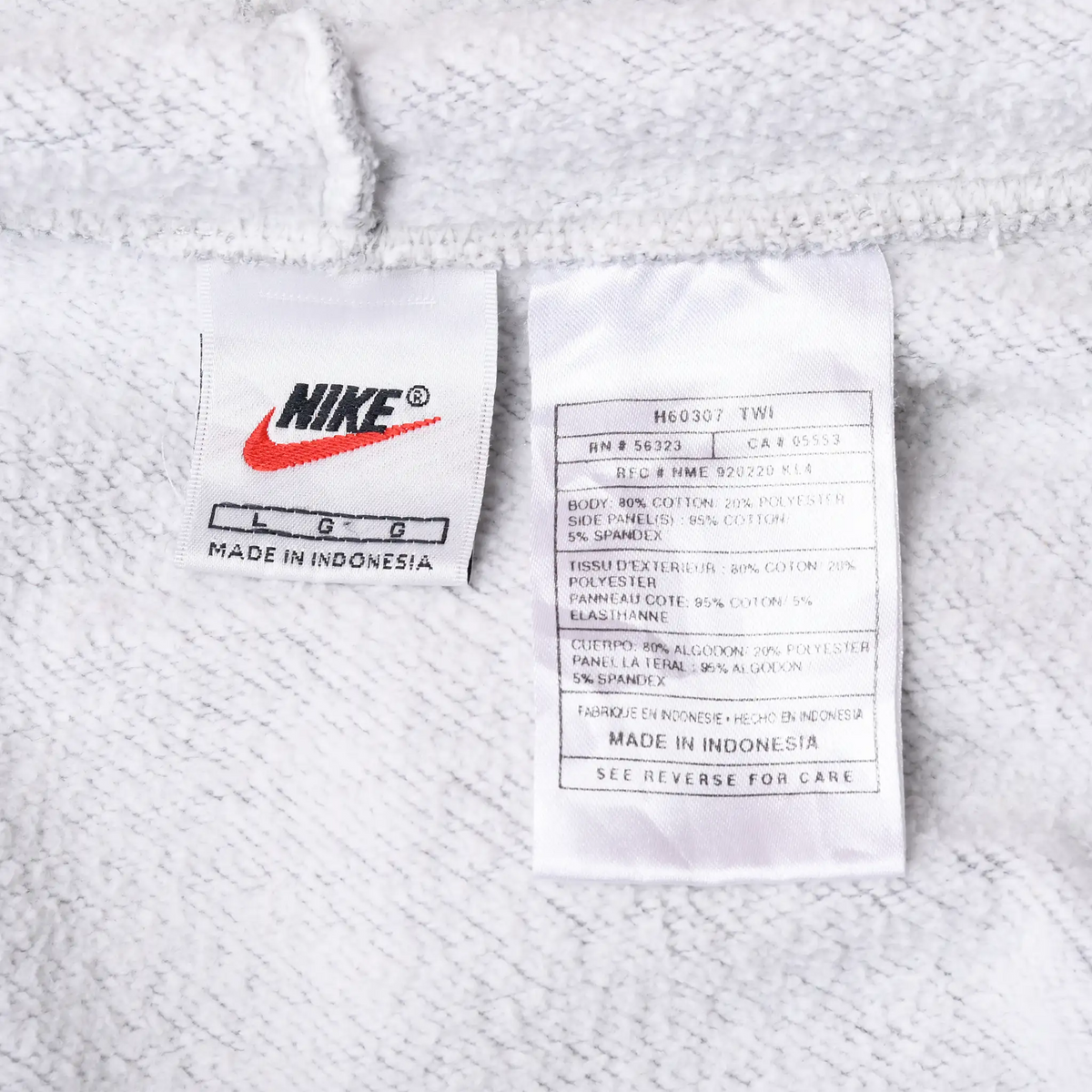 Close-up of Nike neck and care labels marked size large inside grey hoodie