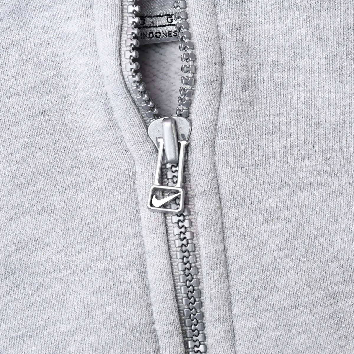 Close-up of quarter zipper and Nike Swoosh pull on grey hoodie