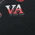 Close-up of red and white VA lettering and copyright text on black hoodie back print