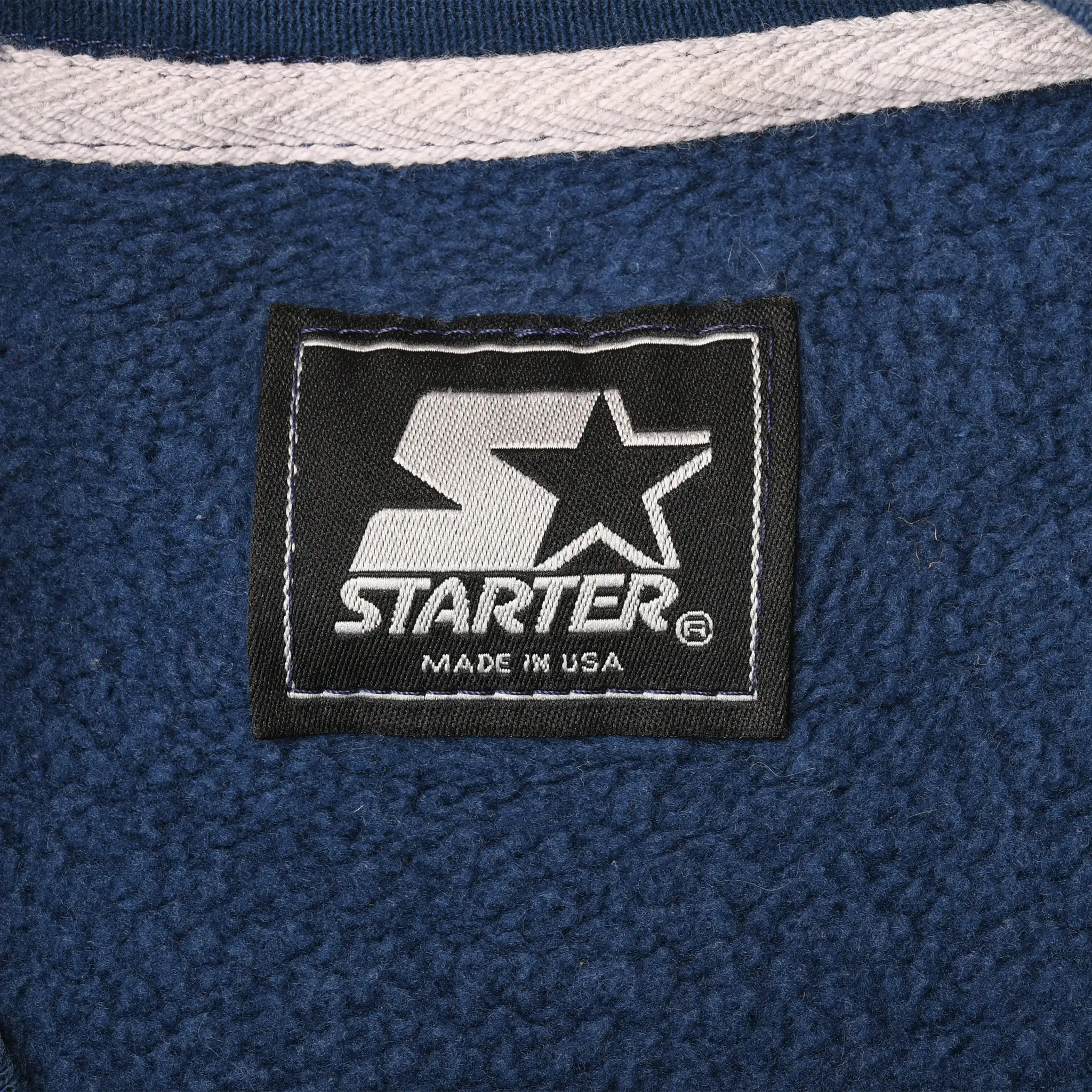 Close-up of black Starter Made in USA neck label inside navy sweatshirt