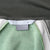 Interior neck label detail on green Nike Athletics track jacket