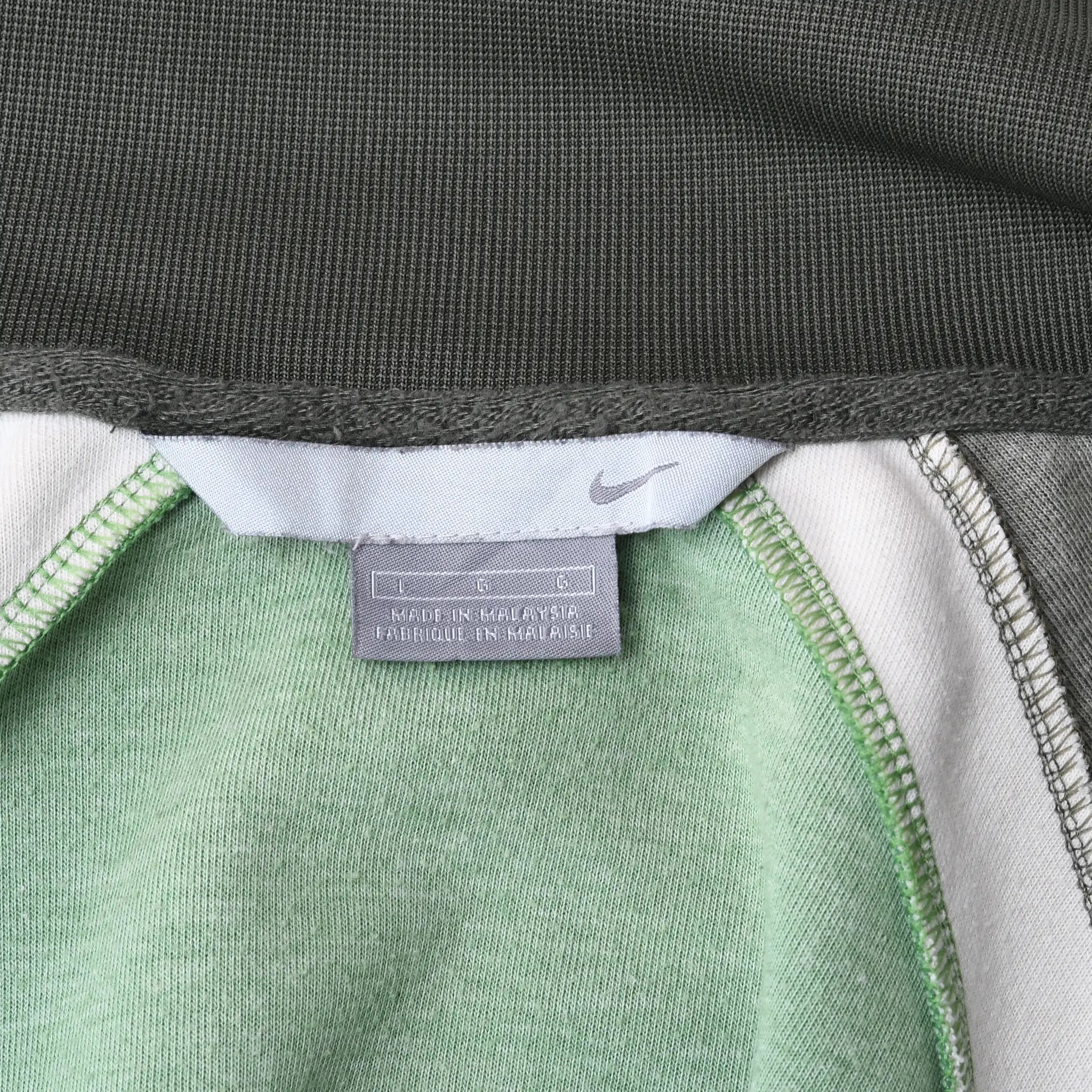 Interior neck label detail on green Nike Athletics track jacket
