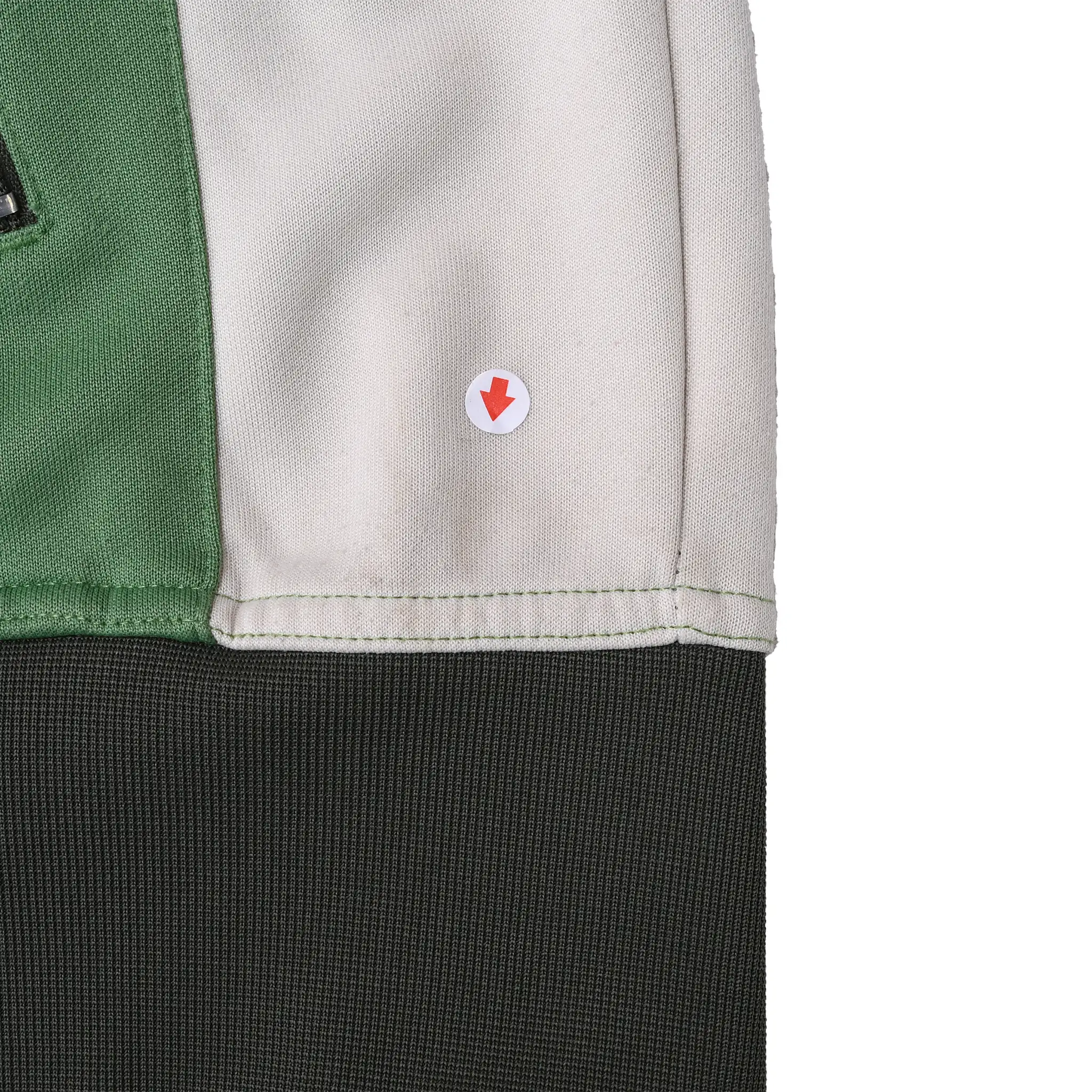 Close-up of interior white panel near dark gray hem with red arrow marking a small spot