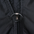 Close-up of the Nike jacket's black front zipper pull with oval cord loop