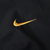 Close-up of yellow Nike Swoosh embroidery on black jacket fabric