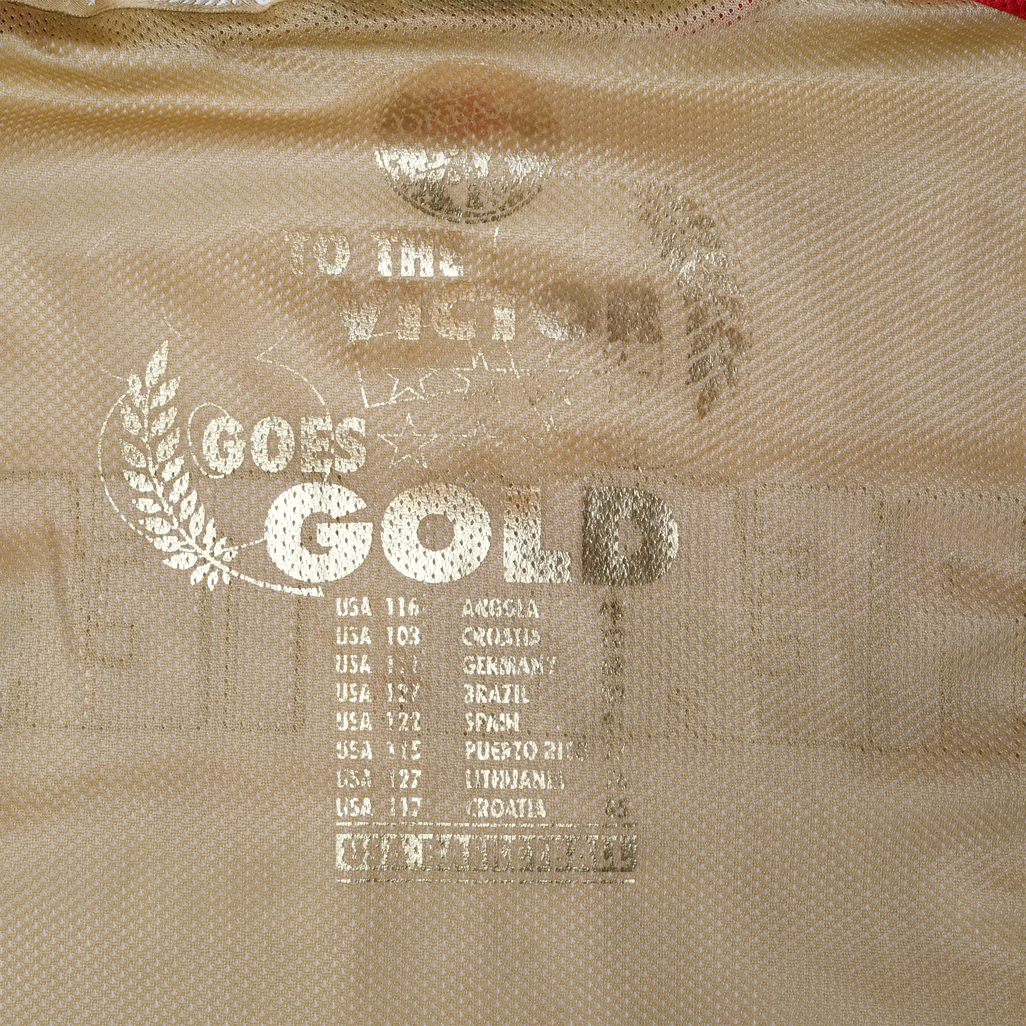 Close-up of faded gold medal history print on the jacket's gold interior lining